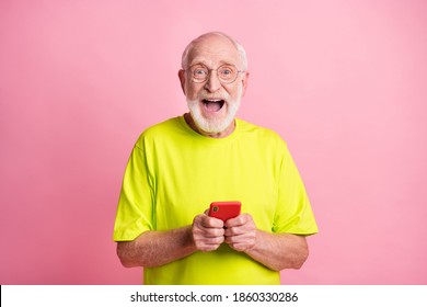 Portrait of impressed handsome old man open mouth unexpected news lime clothing isolated on pink color background