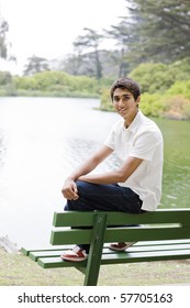 Portrait of an Indain Teenage Boy Sitting on a Park Bench Smiling To Camera