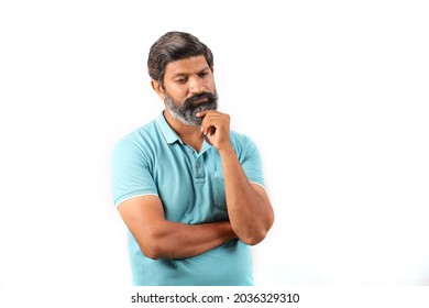 Portrait of an Indian bearded man wearing t-shirt in a deep thinking. Close up expressions white background.