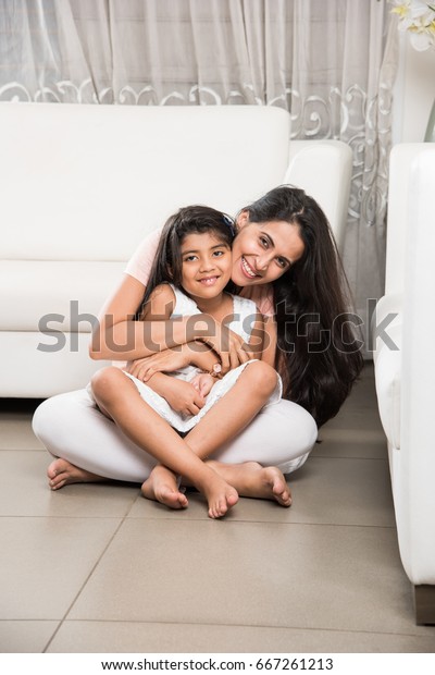 母の膝の上に座るインド人の美しい小さな女の子や娘のポートレート 母は両腕をしっかりと抱き 限定フォーカス の写真素材 今すぐ編集