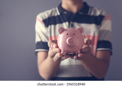 Portrait Of Indian Boy Holding Piggy Bank For Saving Money