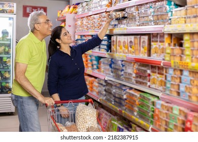 Portrait Of Indian Couple At Grocery Store While Shopping.