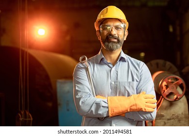 portrait of indian engineer man wearing yellow helmet safety gloves  and holding wrench tool in factory. beard male professional maintenance repair machine at industrial factory.  skill india.  - Powered by Shutterstock