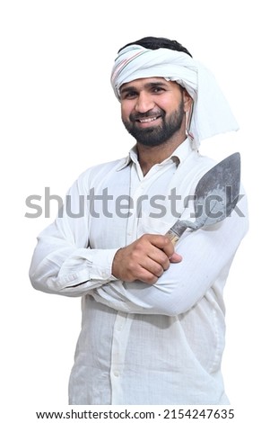Portrait of an Indian farmer holding an axe.