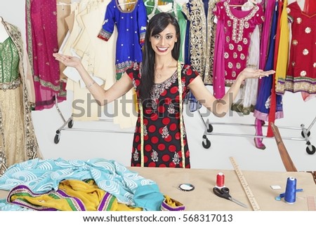 Portrait of Indian female dressmaker with hand gestures at design studio