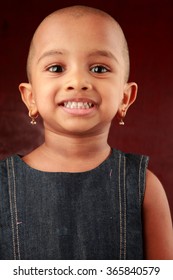 Portrait Of An Indian Girl Child With Shaved Head