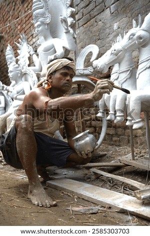 Portrait of an Indian man making different things with clay in village.