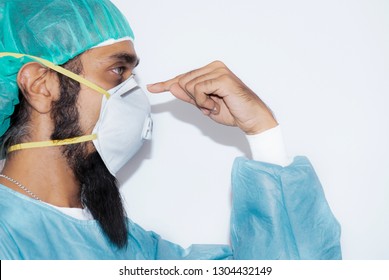 Portrait of Indian man with mustache wearing hat and mask N 95,Handsome bearded man is black hair and dark brown eyes wear white doctor uniform and focus finger to mask and copy space,Sikh man, - Powered by Shutterstock