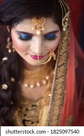 Portrait Of An Indian Muslim Bride Wearing Red Sari With Heavy Jewelry In A Banquet Hall. Traditional Muslim Bride In Wedding.