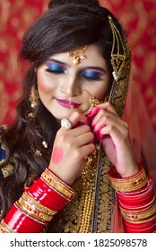 Portrait Of An Indian Muslim Bride Wearing Red Sari With Heavy Jewelry In A Banquet Hall. Traditional Muslim Bride In Wedding.