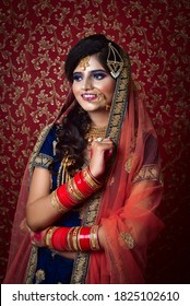 Portrait Of An Indian Muslim Bride Wearing Red Sari With Heavy Jewelry In A Banquet Hall. Traditional Muslim Bride In Wedding.