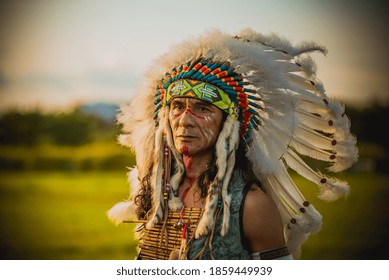 Portrait Indian Red Wearing Traditional Dress With Bird Feature On Head With Nature Background.