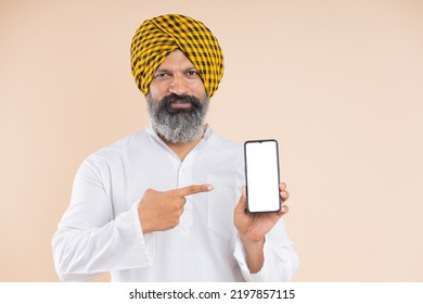 Portrait Of Indian Sikh Farmer Pointing Towards The Mobile 