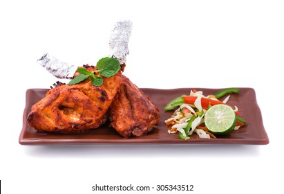 portrait of indian tandoori chicken served with salad isolated on white background
