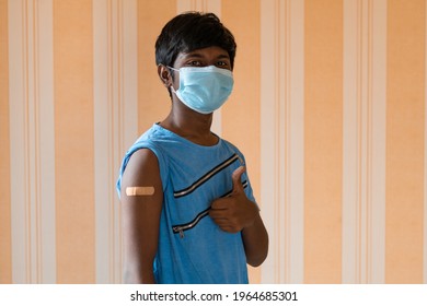 Portrait Of An Indian Teen Giving Thumbs Up After Getting Vaccinated And Showing Bandage On His Arm