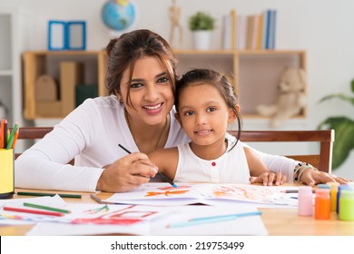 Portrait of Indian woman and her daughter painting together