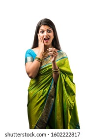 portrait of indian woman in saree and wearing gold jewellery, standing with cheerful expressions, elegant pose over white background