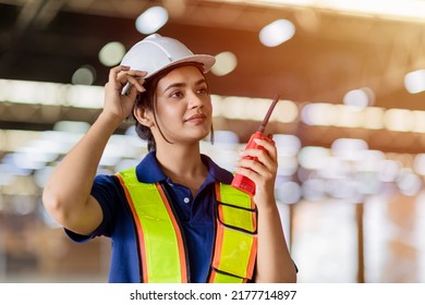 Portrait Indian woman worker supervisor with engineer safety suit work in large factory warehouse - Powered by Shutterstock