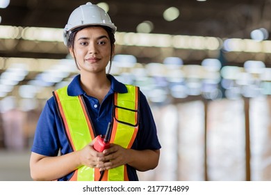 Portrait Indian woman worker supervisor with engineer safety suit work in large factory warehouse - Shutterstock ID 2177714899