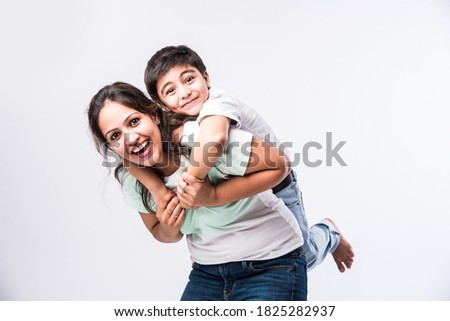 Portrait of Indian young mother and son against white background, looking at camera