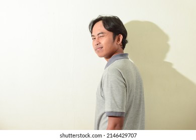 Portrait Of An Indonesian Man. The Expression On The Face Of The Asian Man Smiling With A Wink. Portrait Of Indonesian People On White Background Background. Girl Seductive Expression
