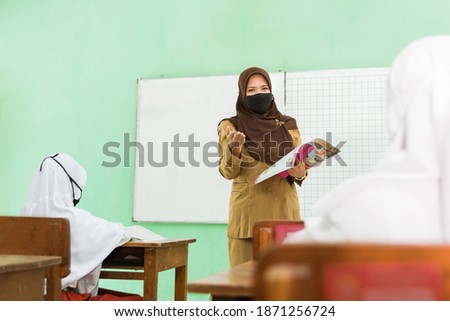 a portrait of Indonesian muslim teacher teaching activities in pandemic situation using health masks