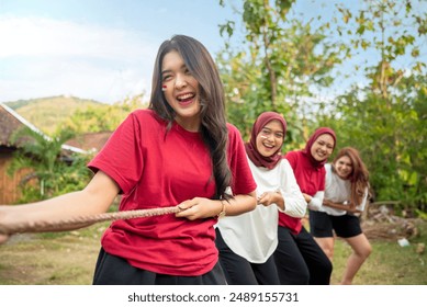 Portrait of Indonesian woman celebrate Indonesia Independence Day with traditional events like a tug of war contest outdoor - Powered by Shutterstock