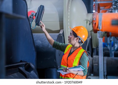 Portrait industry worker under checking the industry cooling tower air conditioner is water cooling tower air chiller HVAC of large industrial building to control air system.