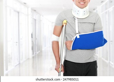 portrait of injured young man use crutch and arm sling - Powered by Shutterstock