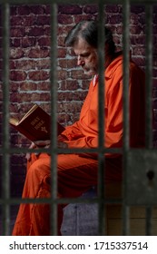 Portrait of an inmate, reading the bible in his cell