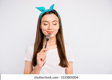 Portrait of inspired dreamy girl hold fork feel hungry want eat imagine tasty meal delicious burger close eyes wear stylish blue headband t-shirt isolated over white color background