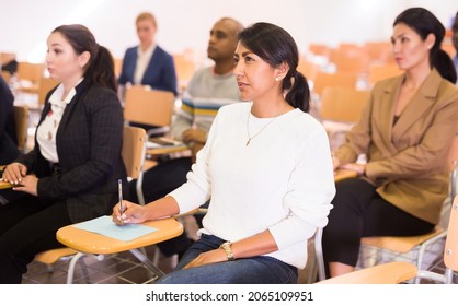 Portrait Of Interested Hispanic Female Entrepreneur Sitting In Conference Hall At Business Event. Business And Entrepreneurship Development Concept..