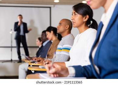 Portrait Of Interested Hispanic Female Entrepreneur Sitting In Conference Hall At Business Event. Business And Entrepreneurship Development Concept..