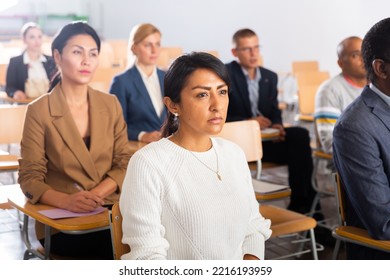 Portrait Of Interested Hispanic Female Entrepreneur Sitting In Conference Hall At Business Event. Business And Entrepreneurship Development Concept..