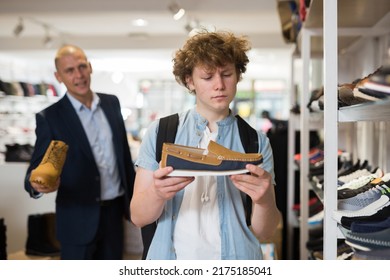 Portrait Of Interested Teenager Looking At Two Tone Suede Mens Loafers While Visiting Shoe Store