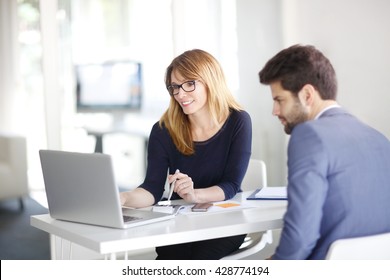 Portrait investment advisor businesswoman sitting at office in front computer   consulting and young professional man  