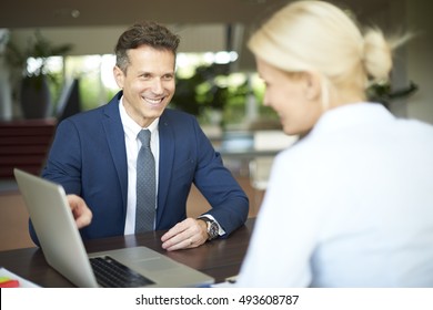 Portrait Of Investment Advisor Businesswoman Sitting At Office In Front Of Computer And Consulting With Her Business Client.