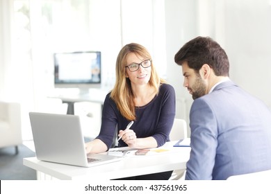 Portrait Of Investment Advisor Businesswoman And Young Financial Businessman Analyzing Data And Working On Laptop.