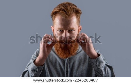 Portrait of Irish man with beard. Serious man twirling moustache. Bearded man with unshaven face