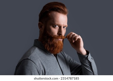 Portrait of Irish man twirling mustache half turn. Bearded man with unshaven face