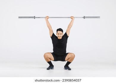 Portrait isolated cutout full body studio shot strong Asian male fitness athlete sportman model in black casual sport workout outfit posing smiling lifting barbell exercising on white background.