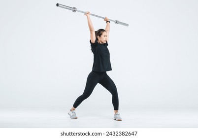 Portrait isolated cutout full body studio shot strong Asian female fitness athlete sportsman model in black casual sport workout outfit posing lifting barbell exercising on white background.