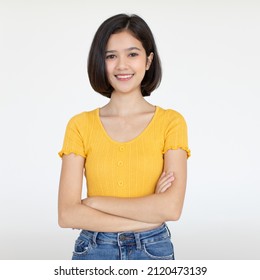 Portrait Isolated Cutout Studio Shot Of Asian Pretty Friendly Young Teenager Short Hair Girl Model In Casual Crop Top Shirt And Jeans Standing Posing Holding Hand On Head Smiling On White Background.