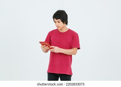 Portrait Isolated Cutout Studio Shot Of Asian Young Handsome Teenager Male Model In Street Style Outfit Standing Holding Tablet Computer In Hands Smiling Taking Selfie Photo On White Background.