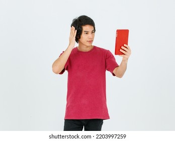 Portrait Isolated Cutout Studio Shot Of Asian Young Handsome Teenager Male Model In Street Style Outfit Standing Holding Tablet Computer In Hands Smiling Taking Selfie Photo On White Background.