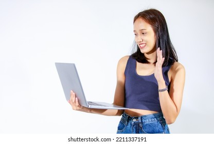 Portrait Isolated Studio Cutout Shot Of Asian Female Model Smiling Look At Camera Holding Pointing Green Blank Screen Laptop Computer Showing Product Promotion Advertisement On White Background.