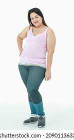 Portrait isolated studio shot of Asian happy healthy strong big fat oversize chubby girl in sport clothing leggings pants standing look at camera smiling posing relax gesture on white background.