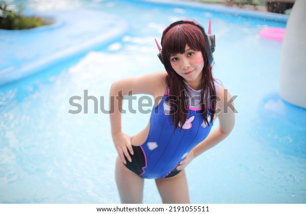 Portrait of Japan anime cosplay girl with swim suit\
at swimming pool