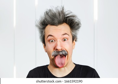 Portrait Of Jocular Aging Man With Grey Long Hair Sticking His Tongue Out In Einstein Manner