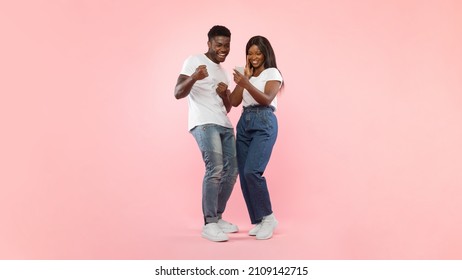 Portrait Of Joyful African American Couple Holding Sharing Smart Phone Shaking Fists In Joy And Excitement, Celebrating Online Win Standing Over Pink Studio Background. Yes, Great News Message Concept - Powered by Shutterstock